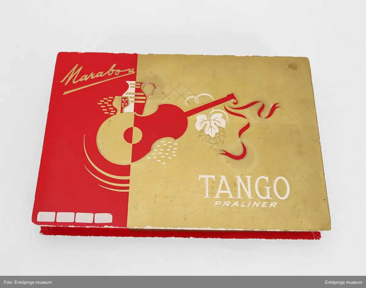 Röd och guldfärgad chokladask från Marabou. Lådan har en gång innehållit chokladpraliner av märket "TANGO PRALINER" från Marabou. Tango var ett chokladmärke som Marabou hade från och med 1926, men just denna ask fanns endast mellan åren 1966 och 1967.