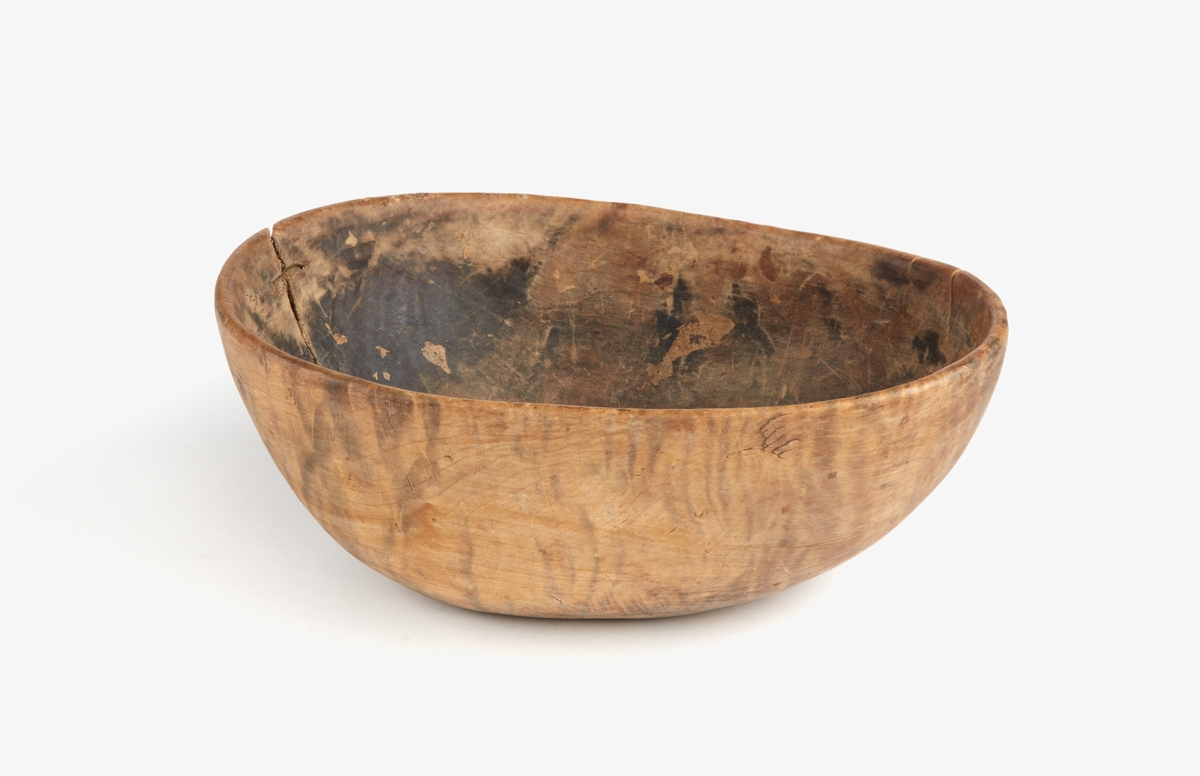 Skål av trä. En stor spricka i ena kortsidan lagad med mässingstråd. Runt botten inristade dalrunor, bla årtal: "1717".
Bilagor finns med en del tolkningar av runorna.