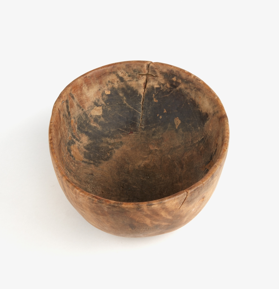 Skål av trä. En stor spricka i ena kortsidan lagad med mässingstråd. Runt botten inristade dalrunor, bla årtal: "1717".
Bilagor finns med en del tolkningar av runorna.