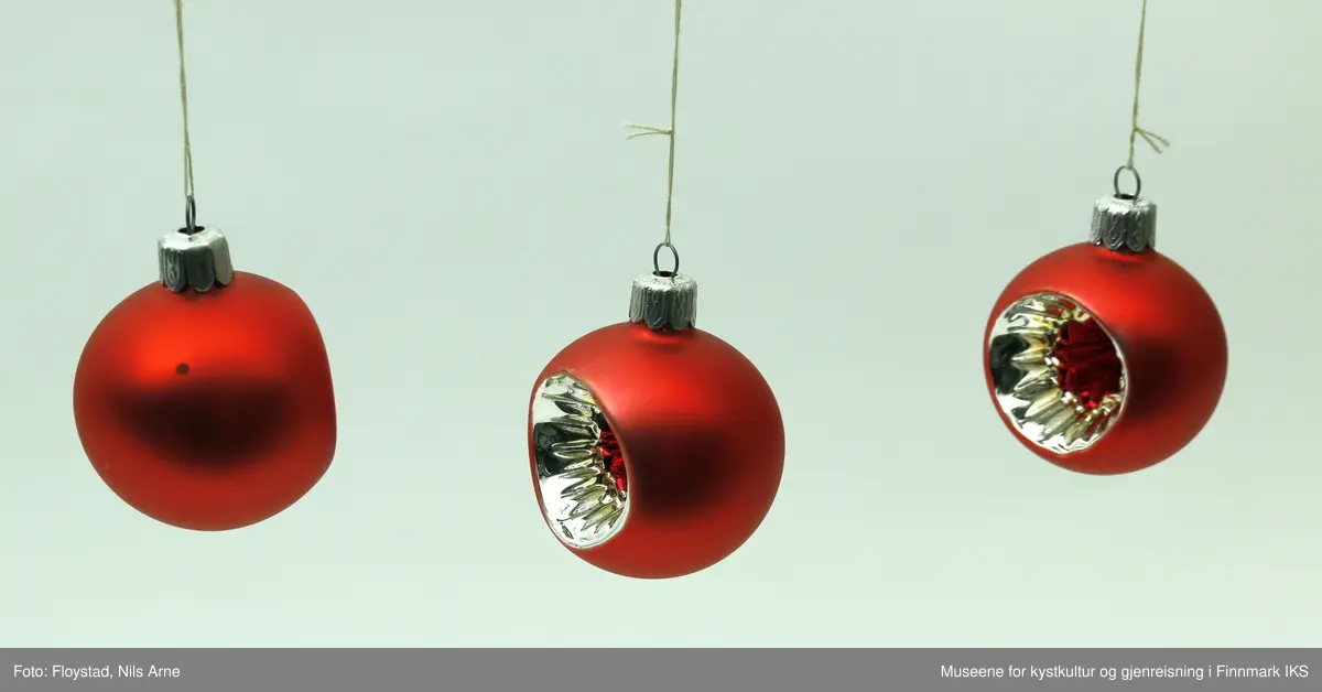 Tre røde julekuler med mønsterformet uthuling på framsiden av kulene. De er alle små i størrelse, men det er en veldig liten forskjell på størrelsen på alle tre. Alle kulene er laget av plastmateriale. Kulene har en halvmatt lysrød farge. Uthulingen på kulene har et stjerneformet mønster som går inn til midten av kulene. Mønsteret har en blank sølvfarge i ytterkanten og i midten har det en blank mørkerødfarge. Helt i midten har mønsteret på uthulingene form som en mørkerød stjerne. Kulene har oppheng i metall med gravert mønsterdekor, som består av små spor og mønster formet som et 8-tall. Opphengene har en liten tråd knytt på.