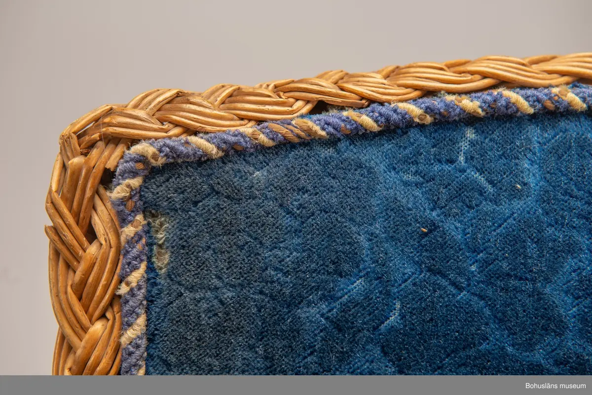 Ur handskrivna katalogen 1957-1958:
Korgstol
H. 117; Br. 59 cm; sits, ryggstöd och armstöd är på "insidan" klädda m. blå, mönstrad plysch. Hel. 
Enligt Brander [Evert Brander, vaktmästare på Uddevalla museum under 1940- och 1950-talen] gjord för Oskar II till Uddevalla - Lelångebanans invigning.
