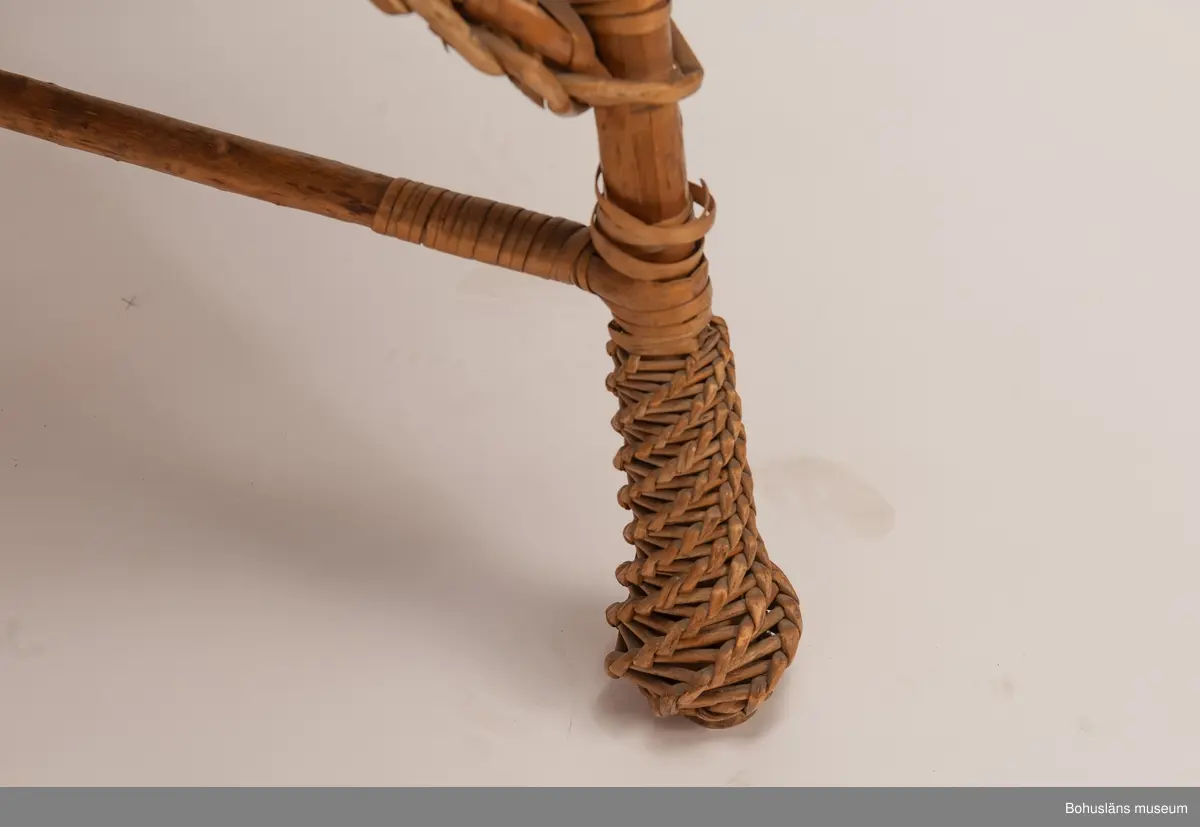 Ur handskrivna katalogen 1957-1958:
Korgstol
H. 117; Br. 59 cm; sits, ryggstöd och armstöd är på "insidan" klädda m. blå, mönstrad plysch. Hel. 
Enligt Brander [Evert Brander, vaktmästare på Uddevalla museum under 1940- och 1950-talen] gjord för Oskar II till Uddevalla - Lelångebanans invigning.