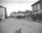 Militärtrupp på häst nedför Kungsgatan, Enköping, vy från torget mot öster, ca 1908.