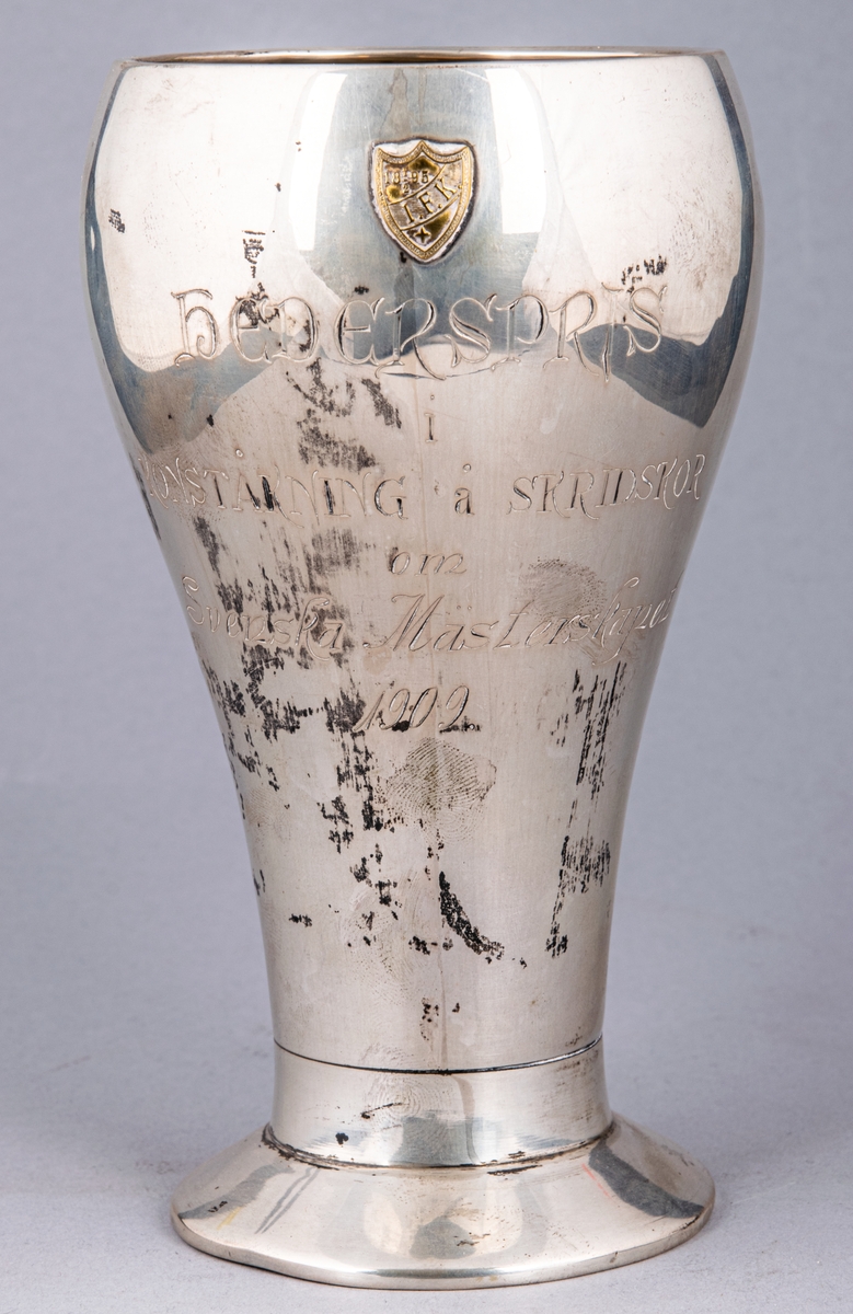 Pokal av silver. Inskription: Hederspris i konståkning å skridskor om Svenska mästerskapet 1909.
Stämplad CGH, F7.