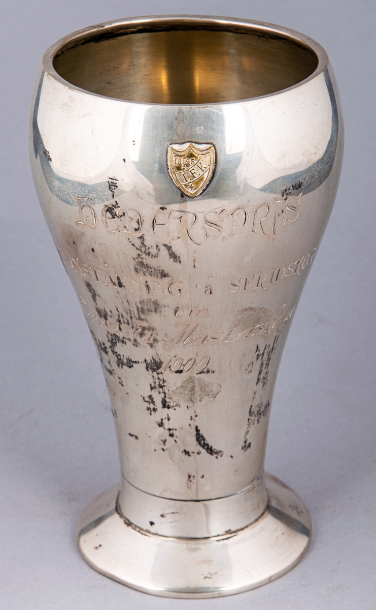 Pokal av silver. Inskription: Hederspris i konståkning å skridskor om Svenska mästerskapet 1909.
Stämplad CGH, F7.