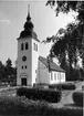 Sättna kyrka. Kyrkan ersatte en äldre träkyrka och stod klar 1742. Den nya kyrkan av trä uppfördes av byggmästare Sam Hasselberg .Ursprungligen hade kyrkan en åttkantig rektangulär planform. Sitt nuvarande utseende erhöll den genom ombyggnaderna 1862 och 1909. Långhuset förlängdes 1909 i väster och försågs med torn och sakristia i nordöst. Tillbyggnaderna gjordes i tegel och putsades. Murar och väggar vitputsades 1909 såväl ut- som invändigt.