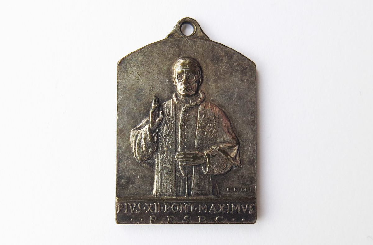 Motiv advers: Pave Pius XII i frontal halvfigur, høyre hevet til velsignelse.

Motiv revers: Peters stol i Peterskirkens kor, flankert av to biskoper.
