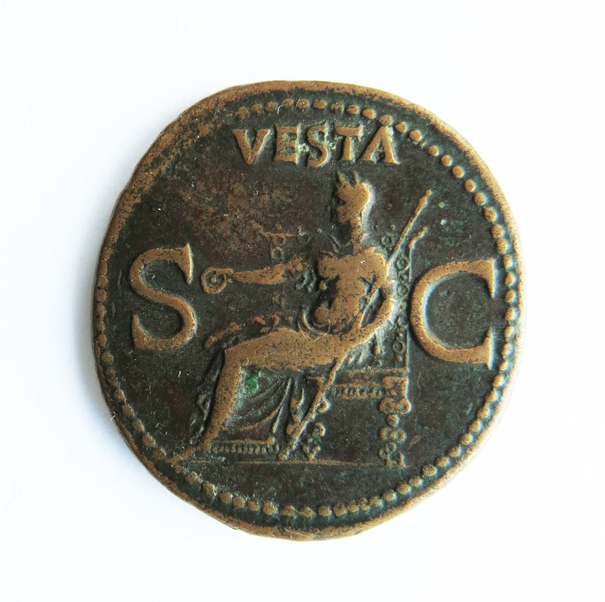 Motiv advers: Keiser Caligula i profil mot venstre.

Motiv revers: Vesta sittende på trone vendt mot venstre. I høyre holder hun en patena, i venstre et langt septer.