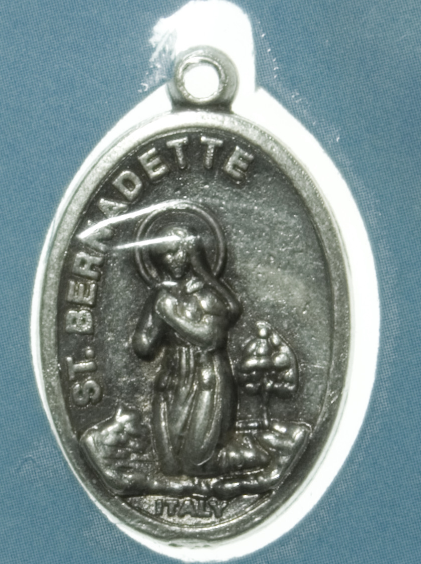 Motiv advers: St. Bernadette Soubirous kneler med hendene foldet i bønn. Hun ser mot visjonen av Maria ved grotten i Lourdes.

Motiv revers: St. Bernadette kneler mot venstre, med foldede hender.