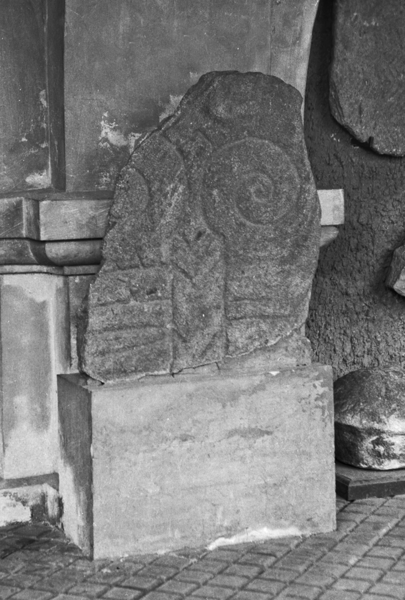 Runestein. St. l. 0,63 m, st. br. 0,52 m. Steinen har dekor og innskriften: "Heden ... ... Bodvar". 

