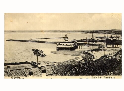 Brevkort, "Warberg. Motiv från fästningen." Utsikt från Varbergs fästning över kallbadhuset till vänster, efter återuppbyggnaden 1903, och varmbadhuset till höger. I förgrunden ses Barnens badstrand och i bakgrunden hamnen. Bilden tagen före 1915.