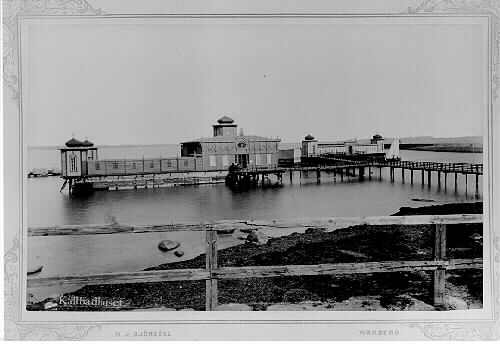 Kallbadhusen vid Barnens badstrand i Varberg, troligen fotograferade hösten 1885. Det vänstra badhuset uppfördes 1866 men skadades svårt i höststormen 1884. Det nya till höger stod klart 1886 och då revs det gamla. Vid julstormen 1902 förstördes kallbadhuset åter, men var återuppfört redan året därpå.