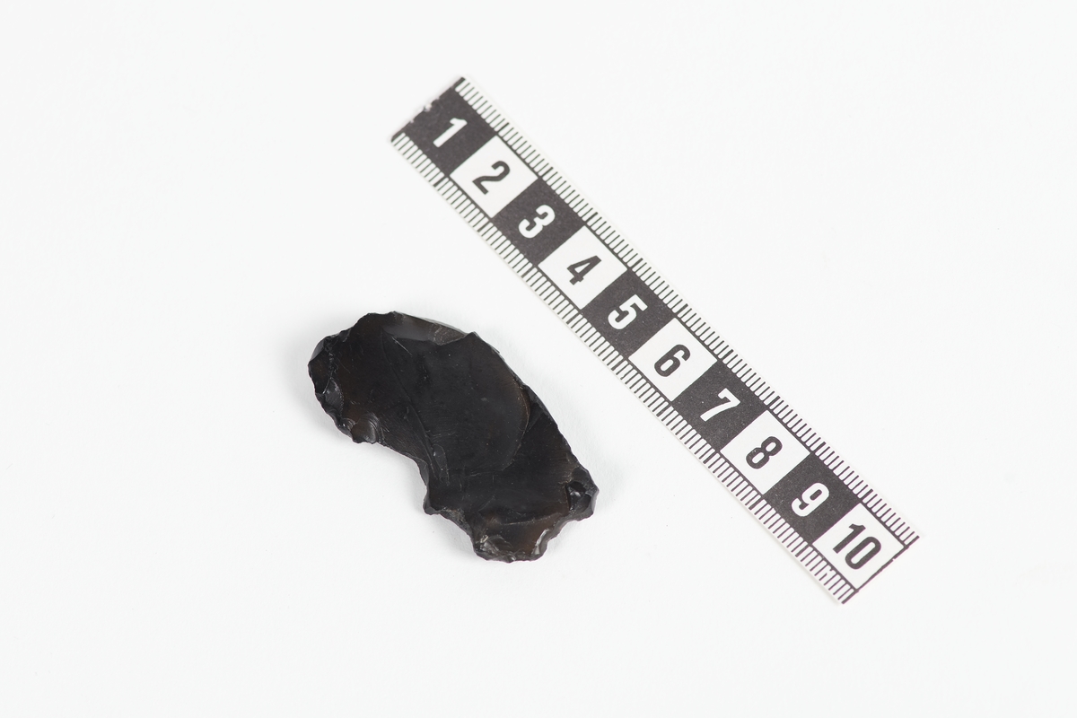 En bit av flinta, eller möjligen vulkaniskt glas, obsidian.