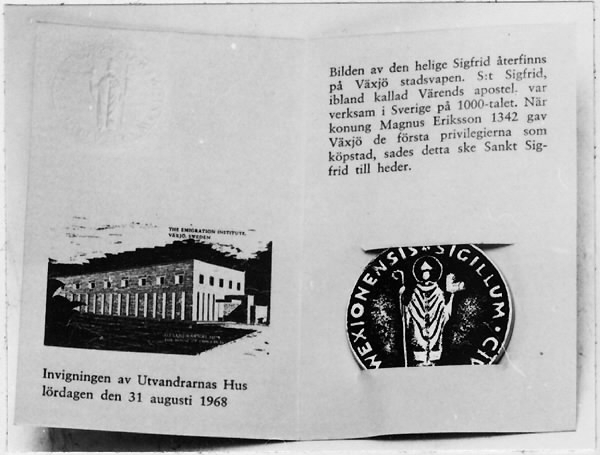 Minnespeng av vitmetall. På framsidan sankte Sigfrids bild och texten SIGILLUM CIVITATIS WEXIONENSIS mot svartanlöpt grund.