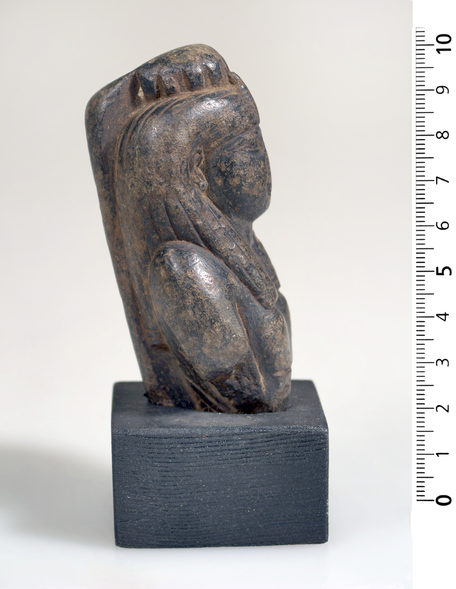 Statue
Øverste halvdel av en statue laget i sort stein. Rekke med hieroglyfer bak. Funnet på øyen Stanehio. 9,5 cm høy.
Stein
