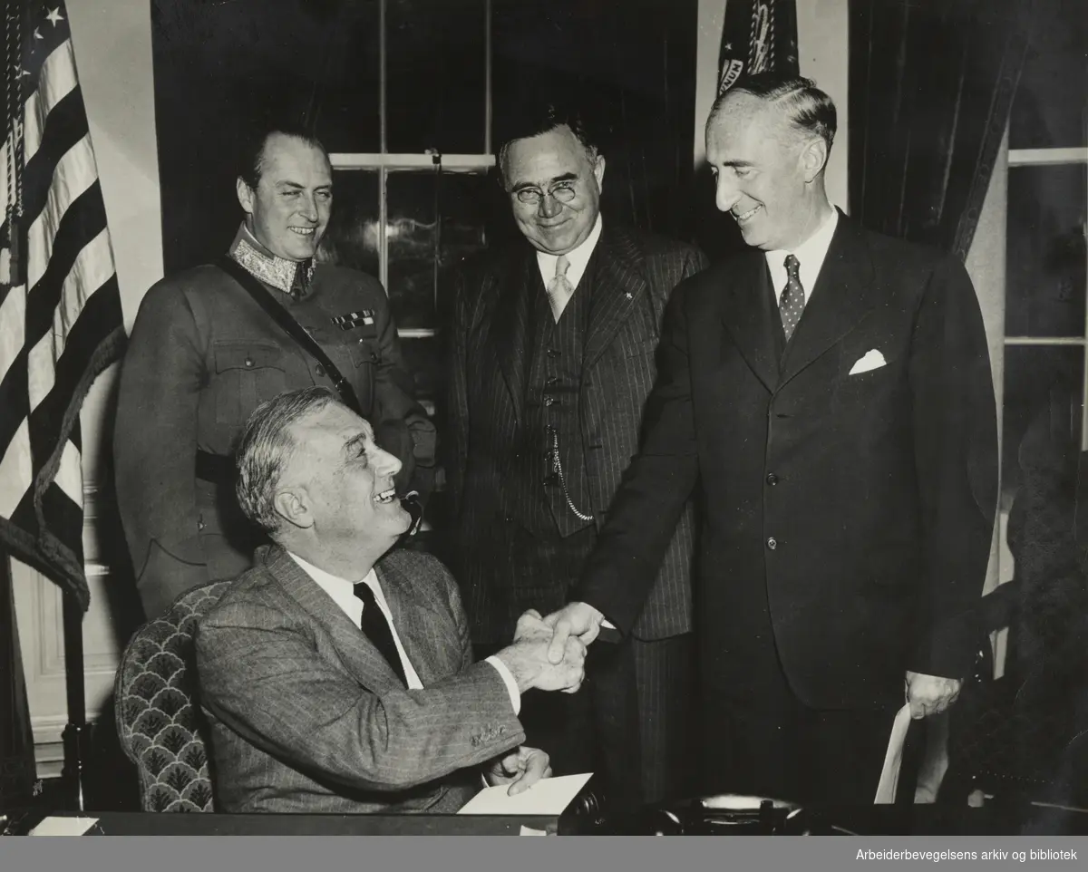 Fra Johan Nygaards Album, Tekst i album: Sendemann Wilhelm Morgenstierne er gitt ambassadør av rang og besøker president Roosvelt i Washington i 1942. På bildet: Sittende Roosevelt, bak Kronprins Olav, Johan Nygaardsvold og Wilhelm Morgenstierne.