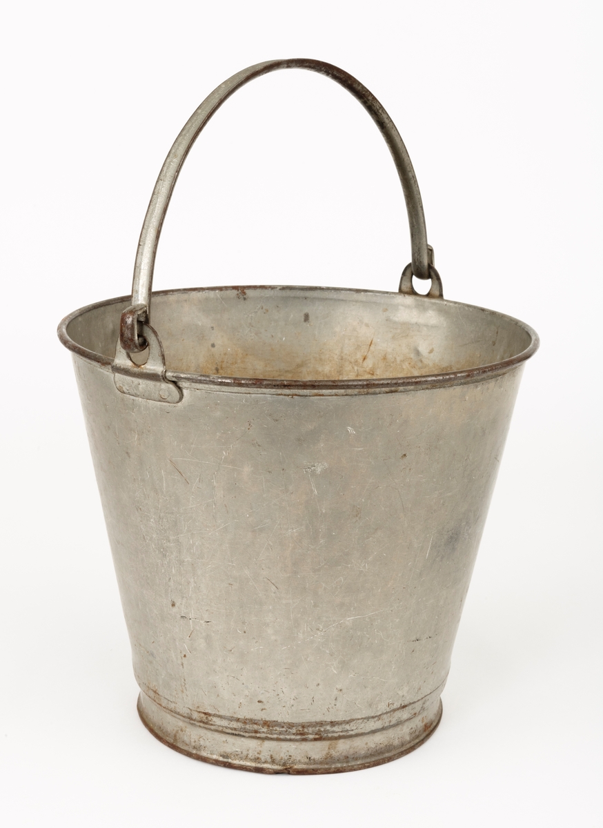 Bøtte av den typen det var vanlig å bære vann i. Bøtta er sveiset ihop av jernblikk. Den er rund, med en diameter som øker fra standflata (18,4 centimeter) til overkanten (27,1 centimeter). Høyden på sjølve beholderen er 23,4 centimeter, regnet fra underlaget til overkanten. I den nedre enden er det en forsterkende fals. Botnplata er noe nedoverbuket. Ved overkanten, diametralt plassert i forhold til hverandre, er det påsveiset «ører» med gjennombrutte hull for feste av bærehanken, som er buet i halvsirkelform. Den ene av disse er plassert over sveiseskjøten som binder plata i sideveggen sammen, og har dermed fungert som forsterkende element i tillegg til å være hankfeste. Hanken er lagd av 2,35 millimeter tjukt galvanisert jern. Den er 1,14 centimeter bred og har et U-formet tverrsnitt, der den runde sida er nedovervendt, slik at hanken ikke skulle gnage i fingrene på bæreren. Bøtta har noe rust i den innvendige botnen, men den er fortsatt tett. Den rommer drøyt 8 liter væske når den fylles breddfull.