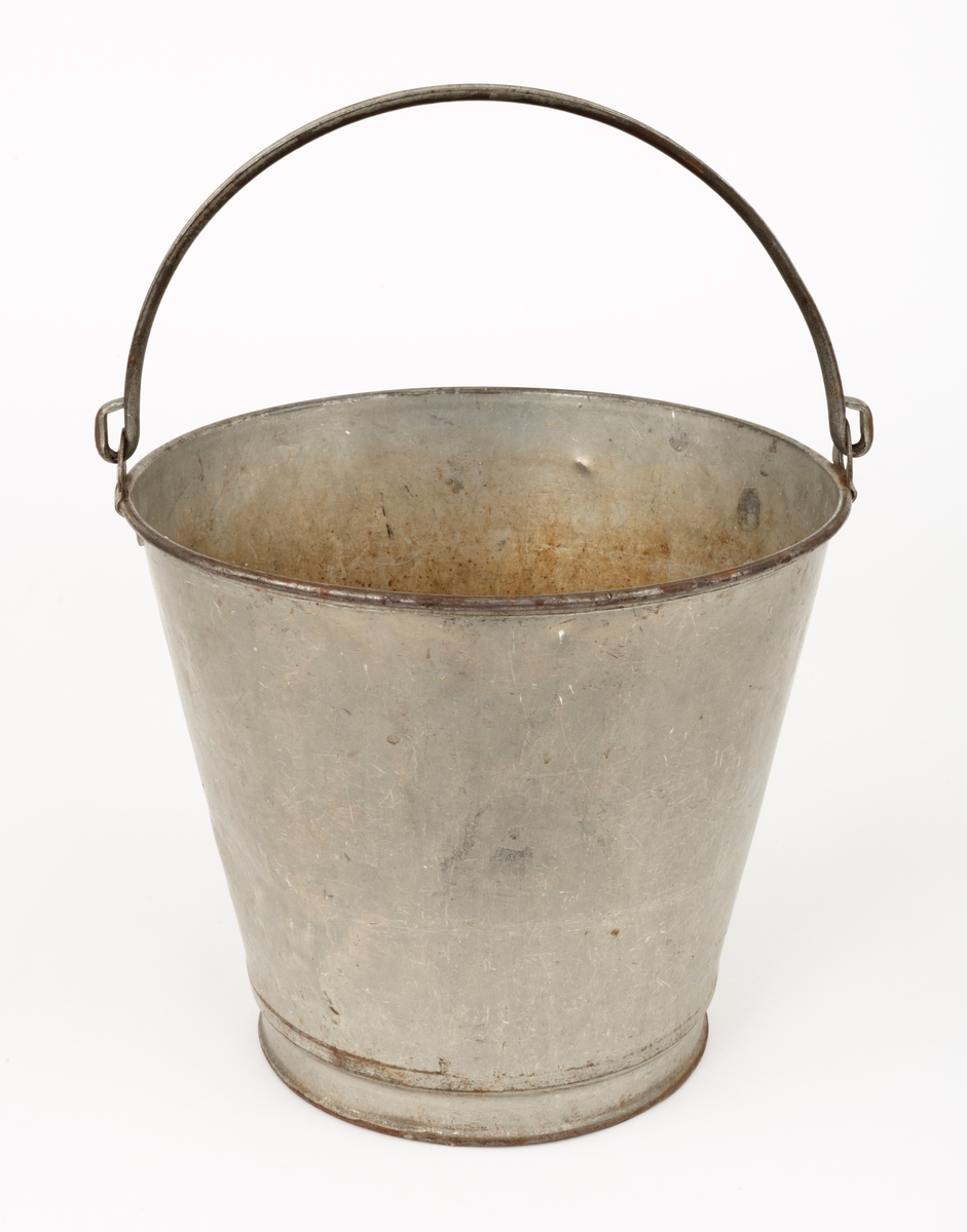 Bøtte av den typen det var vanlig å bære vann i. Bøtta er sveiset ihop av jernblikk. Den er rund, med en diameter som øker fra standflata (18,4 centimeter) til overkanten (27,1 centimeter). Høyden på sjølve beholderen er 23,4 centimeter, regnet fra underlaget til overkanten. I den nedre enden er det en forsterkende fals. Botnplata er noe nedoverbuket. Ved overkanten, diametralt plassert i forhold til hverandre, er det påsveiset «ører» med gjennombrutte hull for feste av bærehanken, som er buet i halvsirkelform. Den ene av disse er plassert over sveiseskjøten som binder plata i sideveggen sammen, og har dermed fungert som forsterkende element i tillegg til å være hankfeste. Hanken er lagd av 2,35 millimeter tjukt galvanisert jern. Den er 1,14 centimeter bred og har et U-formet tverrsnitt, der den runde sida er nedovervendt, slik at hanken ikke skulle gnage i fingrene på bæreren. Bøtta har noe rust i den innvendige botnen, men den er fortsatt tett. Den rommer drøyt 8 liter væske når den fylles breddfull.