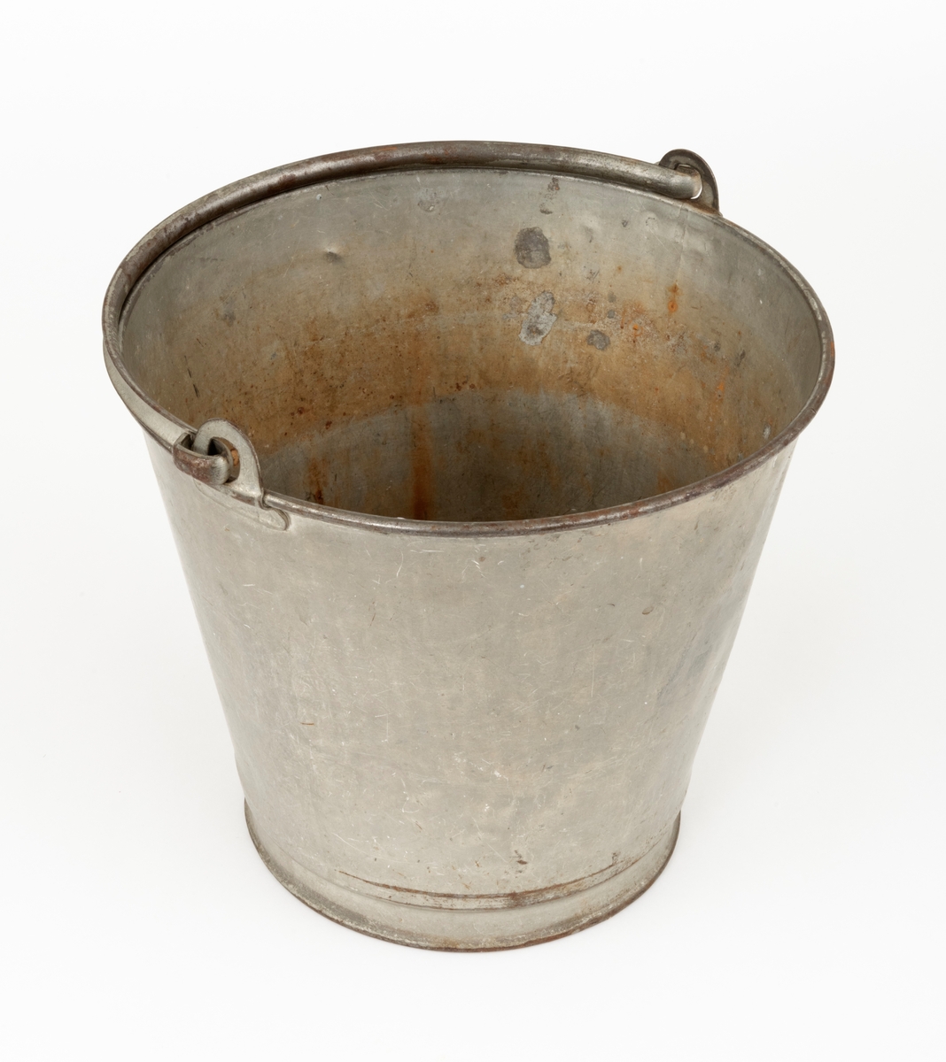 Bøtte av den typen det var vanlig å bære vann i. Bøtta er sveiset ihop av jernblikk. Den er rund, med en diameter som øker fra standflata (18,4 centimeter) til overkanten (27,1 centimeter). Høyden på sjølve beholderen er 23,4 centimeter, regnet fra underlaget til overkanten. I den nedre enden er det en forsterkende fals. Botnplata er noe nedoverbuket. Ved overkanten, diametralt plassert i forhold til hverandre, er det påsveiset «ører» med gjennombrutte hull for feste av bærehanken, som er buet i halvsirkelform. Den ene av disse er plassert over sveiseskjøten som binder plata i sideveggen sammen, og har dermed fungert som forsterkende element i tillegg til å være hankfeste. Hanken er lagd av 2,35 millimeter tjukt galvanisert jern. Den er 1,14 centimeter bred og har et U-formet tverrsnitt, der den runde sida er nedovervendt, slik at hanken ikke skulle gnage i fingrene på bæreren. Bøtta har noe rust i den innvendige botnen, men den er fortsatt tett. Den rommer drøyt 8 liter væske når den fylles breddfull.