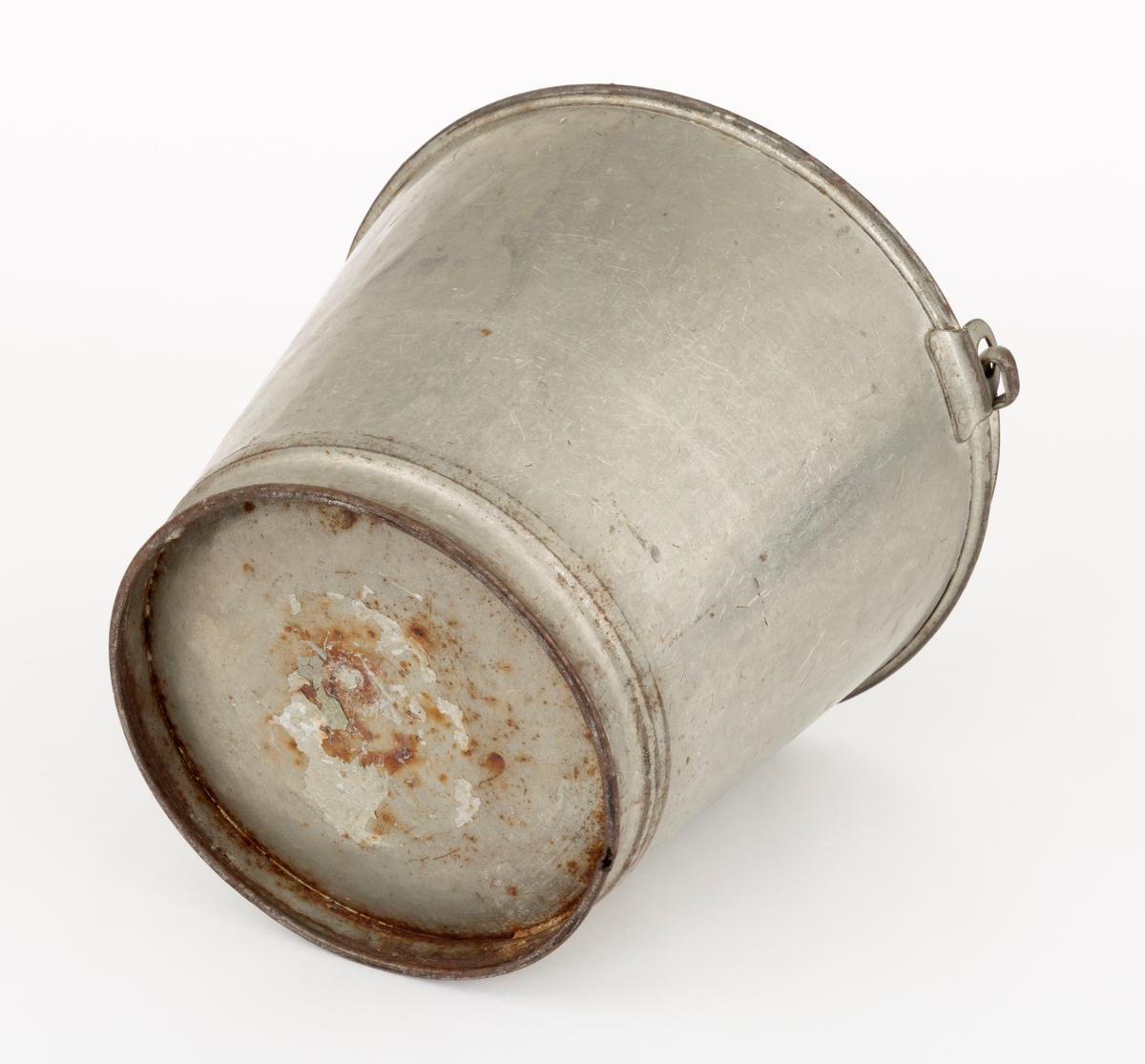 Bøtte av den typen det var vanlig å bære vann i. Bøtta er sveiset ihop av jernblikk. Den er rund, med en diameter som øker fra standflata (18,4 centimeter) til overkanten (27,1 centimeter). Høyden på sjølve beholderen er 23,4 centimeter, regnet fra underlaget til overkanten. I den nedre enden er det en forsterkende fals. Botnplata er noe nedoverbuket. Ved overkanten, diametralt plassert i forhold til hverandre, er det påsveiset «ører» med gjennombrutte hull for feste av bærehanken, som er buet i halvsirkelform. Den ene av disse er plassert over sveiseskjøten som binder plata i sideveggen sammen, og har dermed fungert som forsterkende element i tillegg til å være hankfeste. Hanken er lagd av 2,35 millimeter tjukt galvanisert jern. Den er 1,14 centimeter bred og har et U-formet tverrsnitt, der den runde sida er nedovervendt, slik at hanken ikke skulle gnage i fingrene på bæreren. Bøtta har noe rust i den innvendige botnen, men den er fortsatt tett. Den rommer drøyt 8 liter væske når den fylles breddfull.