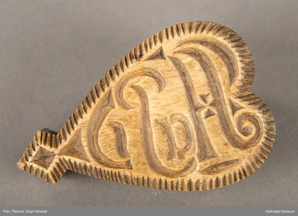 Stempel til å dekorere smør med. Smørroser har gjerne et geometrisk motiv eller botanisk motiv. De er skåret i tre. Hjerteformet, litt avlang hjerte. På ene siden er skjørt inn initialer. På andre siden er det hjerte med greiner og blader ytterst. Langs kanten er det skjært inn et avrundet spor, slik at hjertet er lett å holde i.