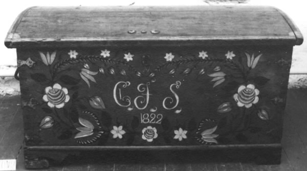 Mindre målad kista med smidda beslag. Kistan står på kistfötter. Locket är svagt välvt och sidorna något utåt vinklade. I locket två snörstumpar fastsatta som höll uppe locket. Smidda beslag i form av gångjärn, i sidorna handtag och fram en nyckelskylt och ett lås. Nyckel saknas. I hörnen smidda beslag, tre i varje hörn. Inuti kistan läddika till höger. Kistan är målad med en blå bottenfärg och hörnbeslagen är målade röda. Runt kistlocket är målat en röd ram. En blomsterkrans inramar monogram och årtal: "CJS 1822". Längst ner i kransen en ros, sedan pingstliljor, tulpan, rosknoppar, ros, tulpaner, knoppar och längst upp pingstliljor. Blommorna är målade i rött, vitt och gult. Blad och stängel i svart. Monogrammet i vitt och rött. Baksidan är målad mörkblå eller svart.