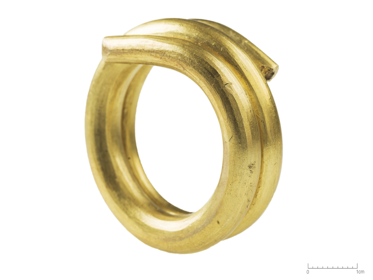 "3904. Betalingsring av guld i 2 1/2 vinding. Ringen, som er saagodtsom av rent guld iblandet med litt sølv, er usædvanlig stor, 5 cm. i ytre tvermaal og veier 172 gram. Selve tenen hvorav den er dannet er 0,8 cm. tyk. (SMÅ 1916, fig. 4)."