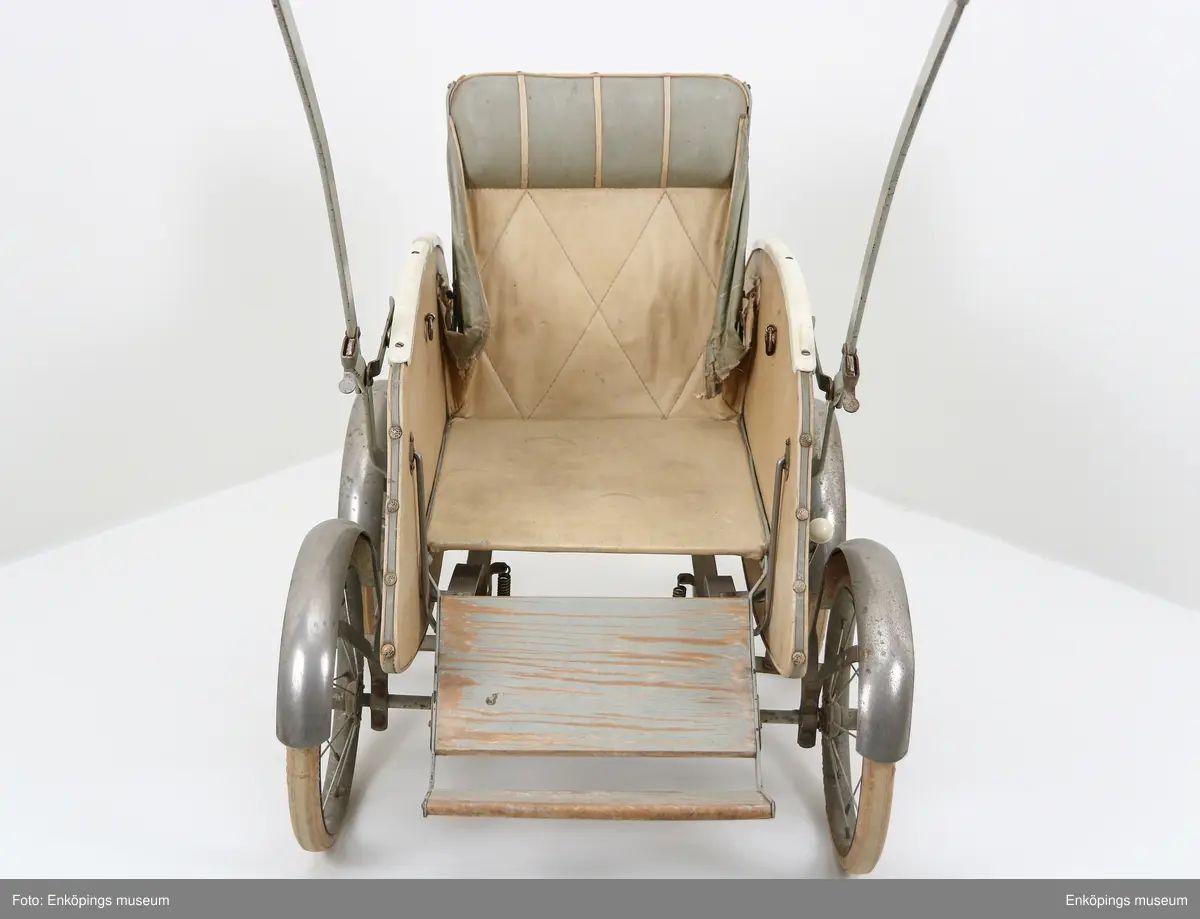 En äldre barnvagn i sittmodell.