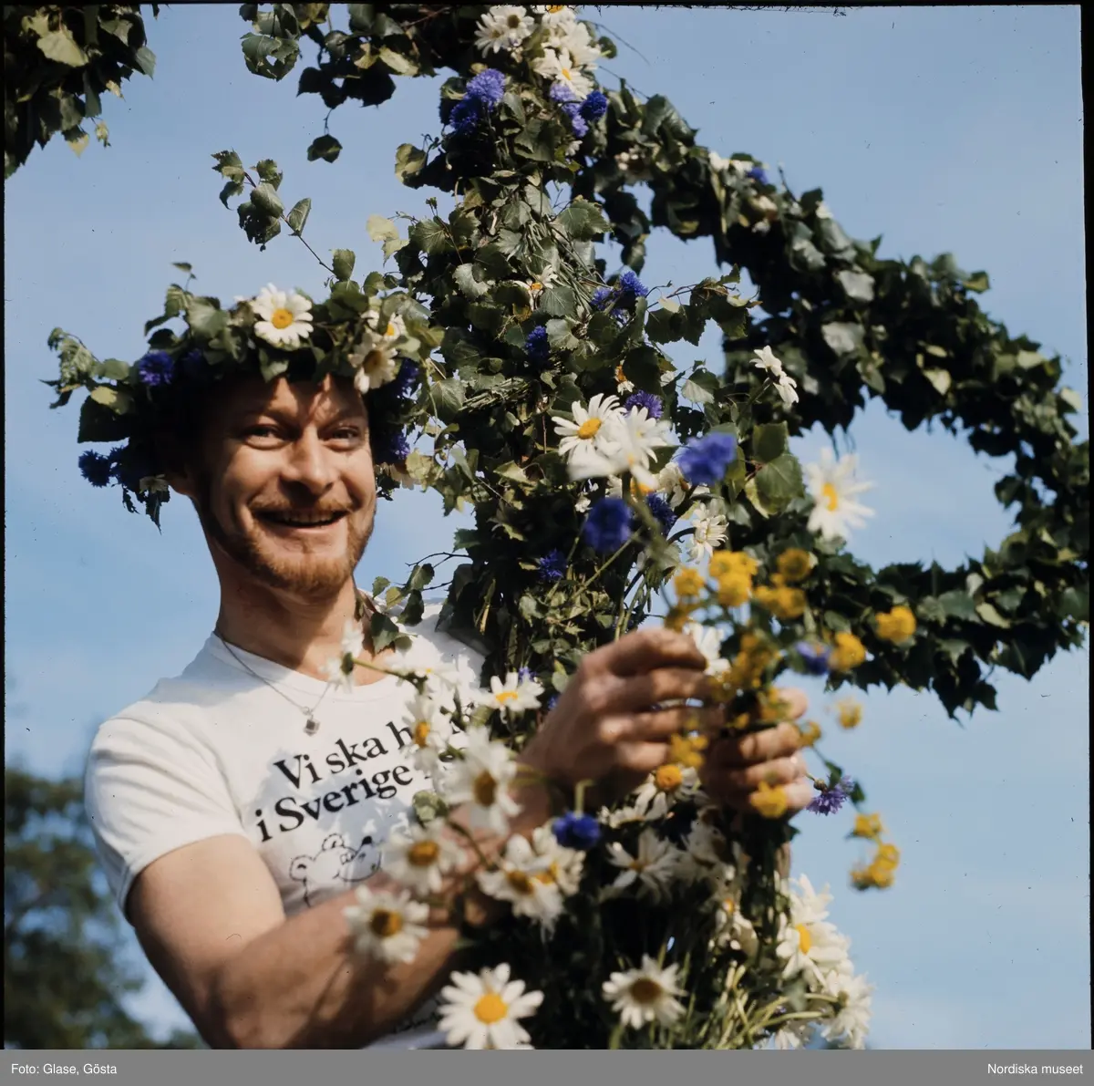 Man och lövad midsommarstång.