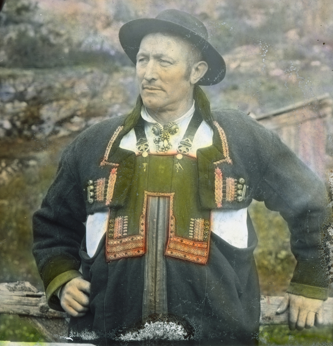 Håndkolorert dias. Portrett av Mikkel Grot kledd i setesdalsdrakt.