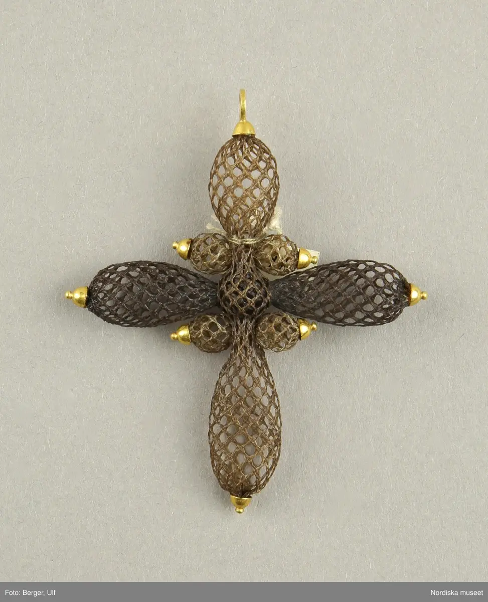 

Huvudliggaren:
"Kors af hår. [föremålet består av endast en del. Litteran berättar bara vilkas hår som ingår i smycket. På katalogkortet visar litteran vems hår som använts till vilka delar av smycket]
a) Vieselgrens hår. (Peter)
b) Scotts hår. (George)
c) Barids hår. (Robert)
[handskrivet tillägg:] alla tre nykterhetskämpar; träffades 1840 i prästgård här i Sverige; korsets hår trol från detta tillfälle /1979-11-28 MP.
G ss 11.738 [=af rådman J. O. Pira och fru A. M. E. Pira född Saefström. ] 7/8 1876."