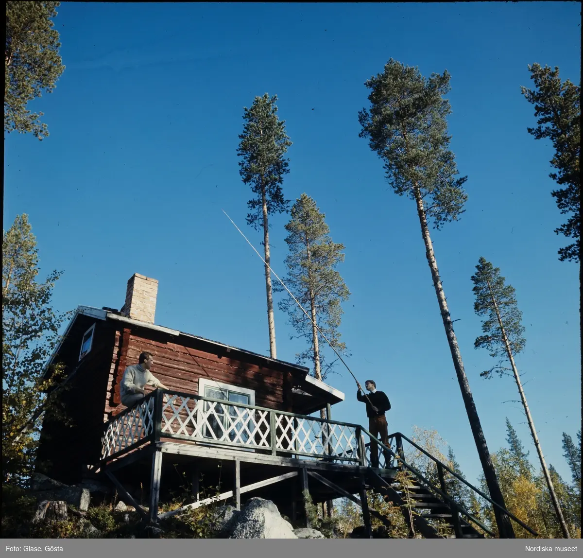 Två män på altanen till en fiskestuga vid Vindelälven, Sorsele.