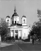 Domkyrkan sedd från Storgatan.; Arkitekt Johan Adolf Hawerman. Nyklassistisk stil. Vitputsad stenkyrka med ett mittorn, två mindre torn och västfasad med pelarrad.En del inventarier från den äldre kyrkan bland annat altartavlan från 1700-talet.Treskeppigt kyrkorum. Orgel från 1731 av Johan Caliman med barockfasad av Magnus Granlund från Hudiksvall