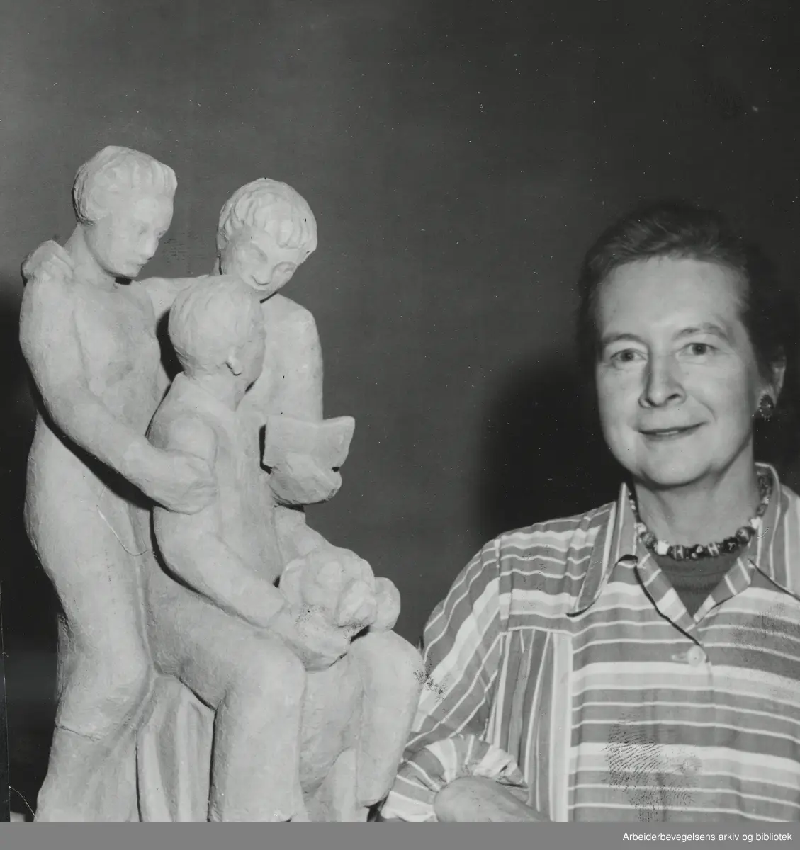 Billedhuggeren Maja Refsum, egentlig Thea Marie Refsum (1897 - 1986) med skulpturgruppen "Min familie" i Kunstnerforbundet, April 1954. Arbeidermagasinet/Magasinet for Alle