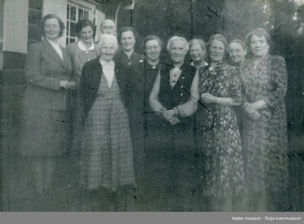 Hytta Trollstua ved Andersby i Vadsø kommune. Gruppebilde av kvinner, ca 1940 tallet. Lilly Simonsen nr to fra høyre, og Gunnar Simonsen bak nr tre fra venstre.  Antatt Gamlehjemsforeningen.