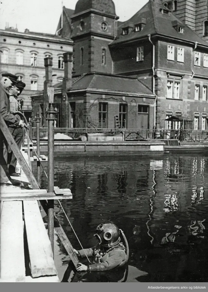 Dykkerarbeid i Spree. "Forstøtningsgrunnen langs Spree blir med visse mellomrum eftersett av dykkere". Udatert. Arbeidermagasinet