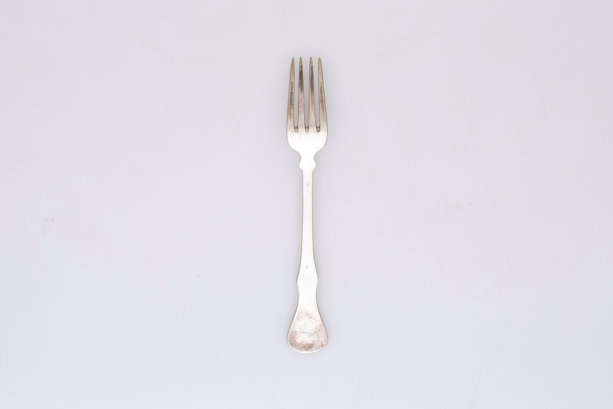 Gaffelen har fire tinder og et fiolinformet skaft. Mønsteret er et musling- eller skjellmønster med rifler langs skaftet.