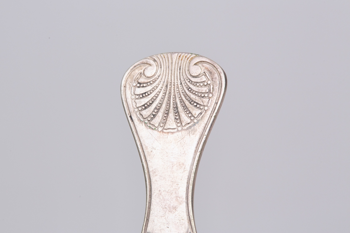 Gaffelen har fire tinder og et fiolinformet skaft. Mønsteret er et musling- eller skjellmønster med rifler langs skaftet.