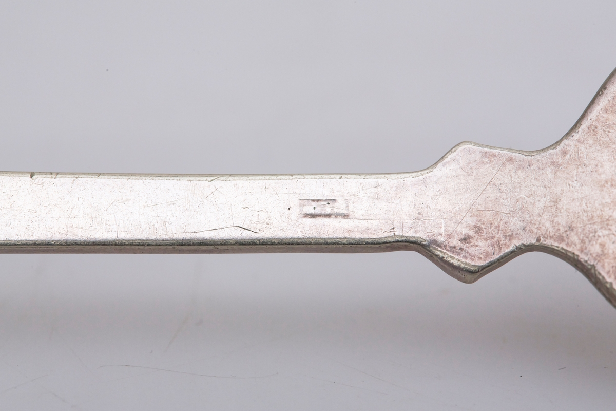 Gaffelen har fire tinder og et fiolinformet skaft. Mønsteret er et musling- eller skjellmønster med rifler langs skaftet.