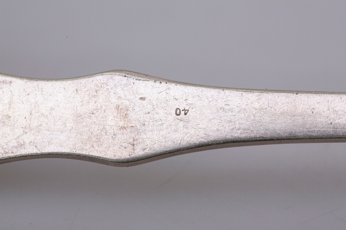 Gaffelen har fire tinder og et fiolinformet skaft. Mønsteret er et musling- eller skjellmønster med rifler langs skaftet.