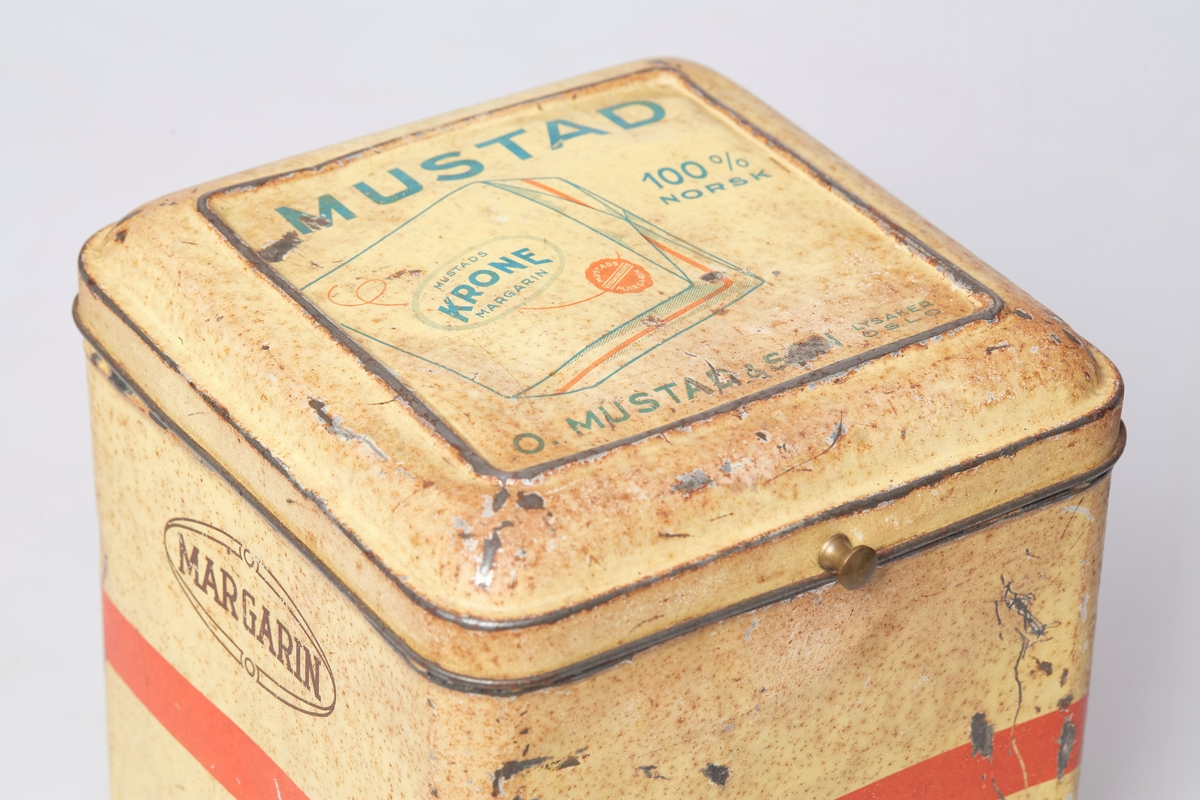 Kvadratisk blikkboks med hengslet lokk, brukt til oppbevaring og salg av Mustad margarin.