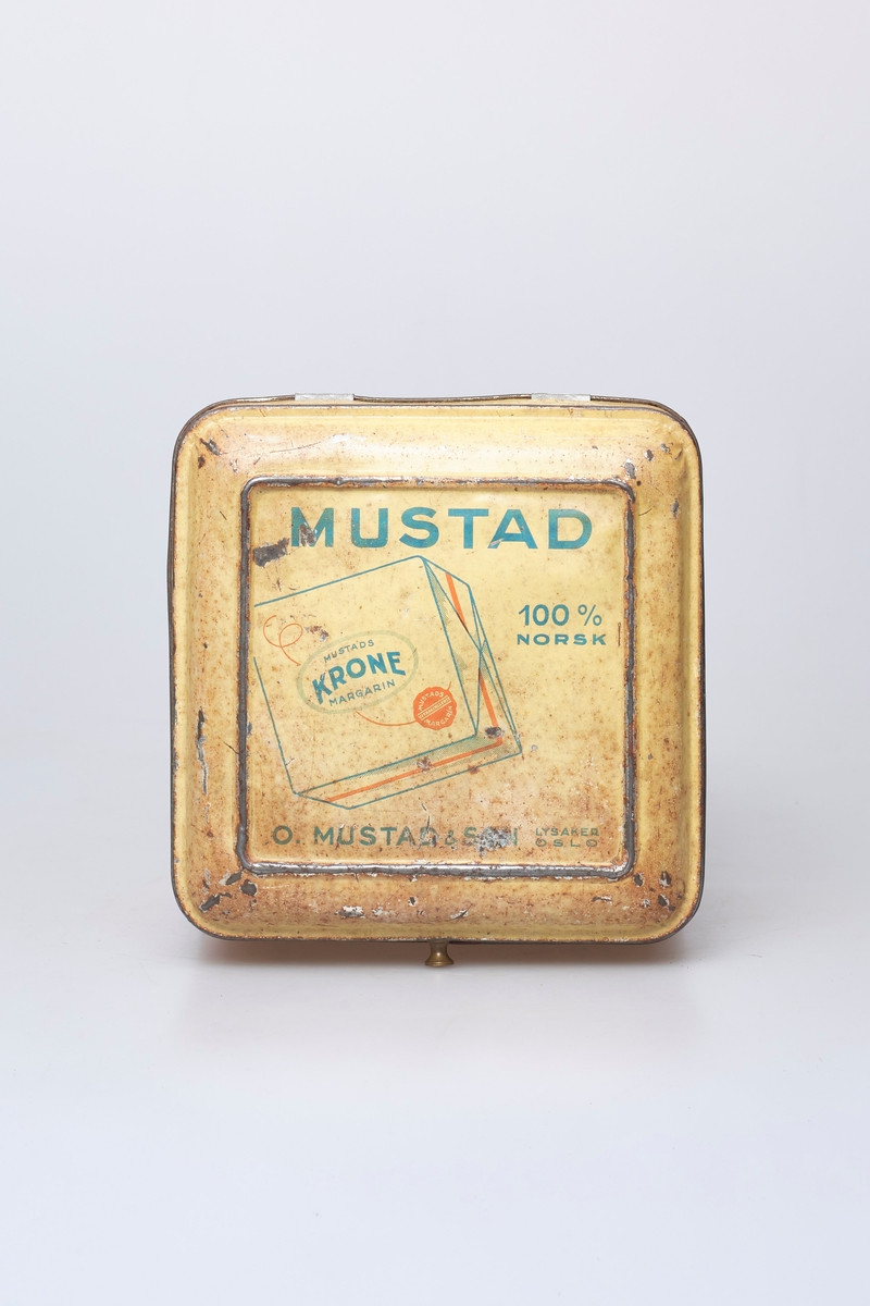 Kvadratisk blikkboks med hengslet lokk, brukt til oppbevaring og salg av Mustad margarin.