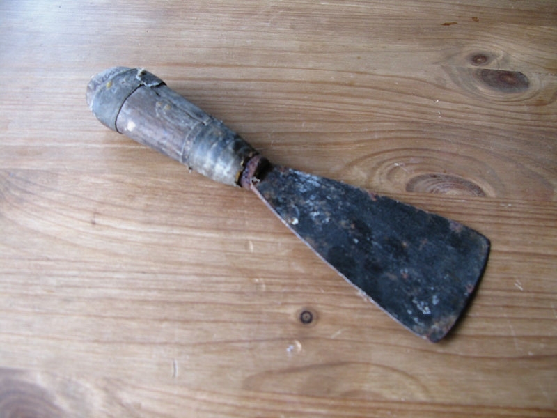 Spate. [oläsl] Skaft av trä, blad av metall. Skaftet är lagat, förstärkt med textilremsor.