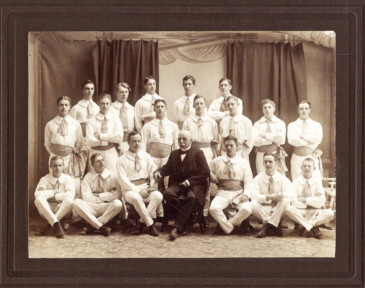 Växjös gymnastiktrupp 1912.
Ateljéfoto med ledaren, överstelöjtnant Olof Bratt i centrum.
Text på baksidan: "(Växjö gymnastik- och idrottsförening (fd läroverkets).
Carl-Oscar Agell, Tage Brauer, Erik Danielsson, Erik Åhlén, Martin Berggren, Eric Görgensson, John Bratt, Erik Zackrisson, Ernst Burman,....Parck, Olof Jonasson, Eric Ahl, Erik Smith, överstelöjtnant Bratt, Gösta Moberg, Einar Holmér, ...Karlsson, Alf Swanström, ....Müller".