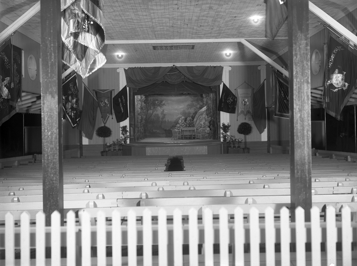 Odaterad bild från omkring 1930 som rimligtvis ger oss en sann bild av hur scenhuset i Linköpings Folkets park tog sig ut i sitt ursprungliga skick. Anläggningens starka anknytning till arbetarrörelsen manifesteras av mängden fackföreningsfanor. Anläggningen står sedan 2015 återuppförd i friluftsmuseet Gamla Linköping.