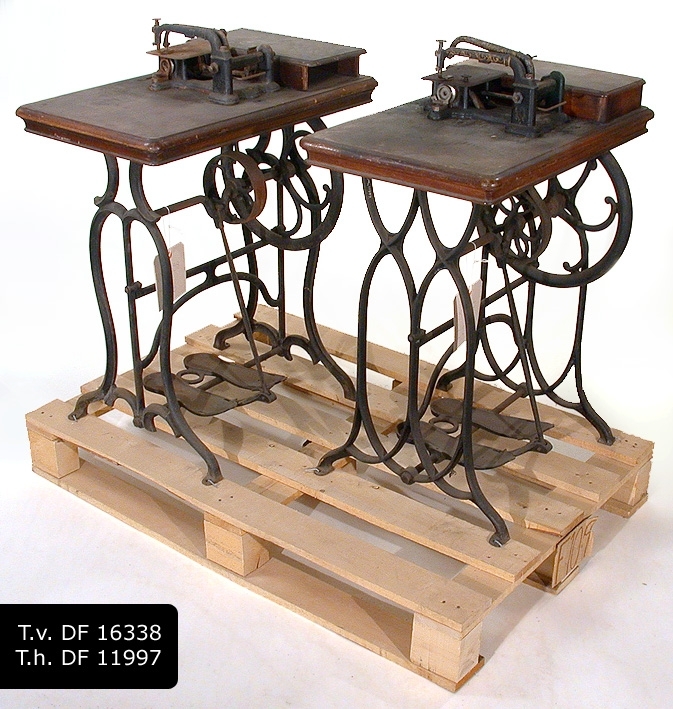 Symaskin på ett sybord av rektangulär brunmålad träskiva med förvaringslåda till vänster, bredvid maskinen. Svartmålad järnställning med två fotsulor som fotplatta
Tillbehör i förvaringslåda: 
:1 Fyra stycken spolar med hjulformiga trissor.
:2 Tre stycken fällvikare.
:3 Två stygnplåtar. 
:4 Vadermått.
:5 Tråduppläggare.
:6 Spolreglerare.
:7 Trådreglerare.
:8 Trådreglerare till brodering.
En styck järn (H) som används vid brodering fattas.