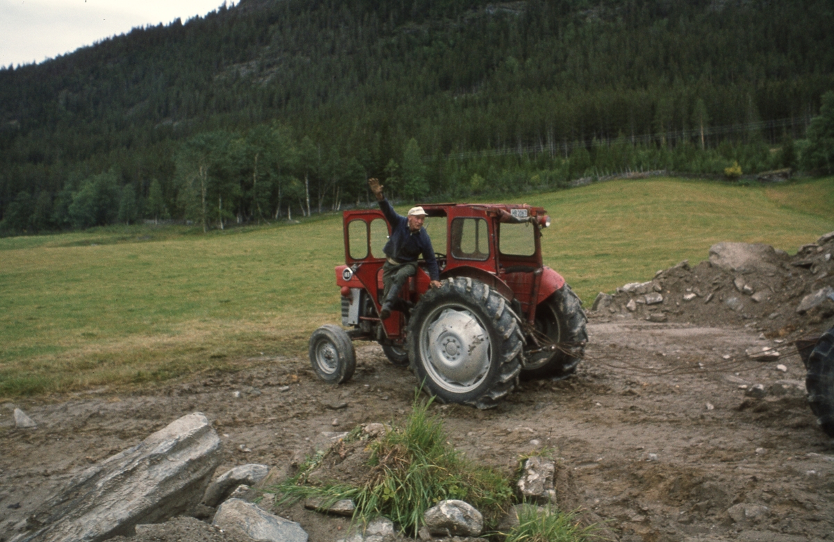 Mann hopper ut av traktor