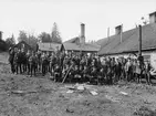 Personalen vid Borggårds bruk 1905. Vid tiden hade brukets omställning från stångjärnstillverkning mot redskap och järnartiklar pågått en tid. Grepar, tjugor, spadar och skyfflar var som synes viktig del i produktionen, men tiden pekade mot mindre artiklar som krokar, söljor och skruvar med mera. I mannen med högst position i bilden, såväl som i realiteten, iklädd något ljusare kostym ser vi brukets delägare Adolf Trägårdh.