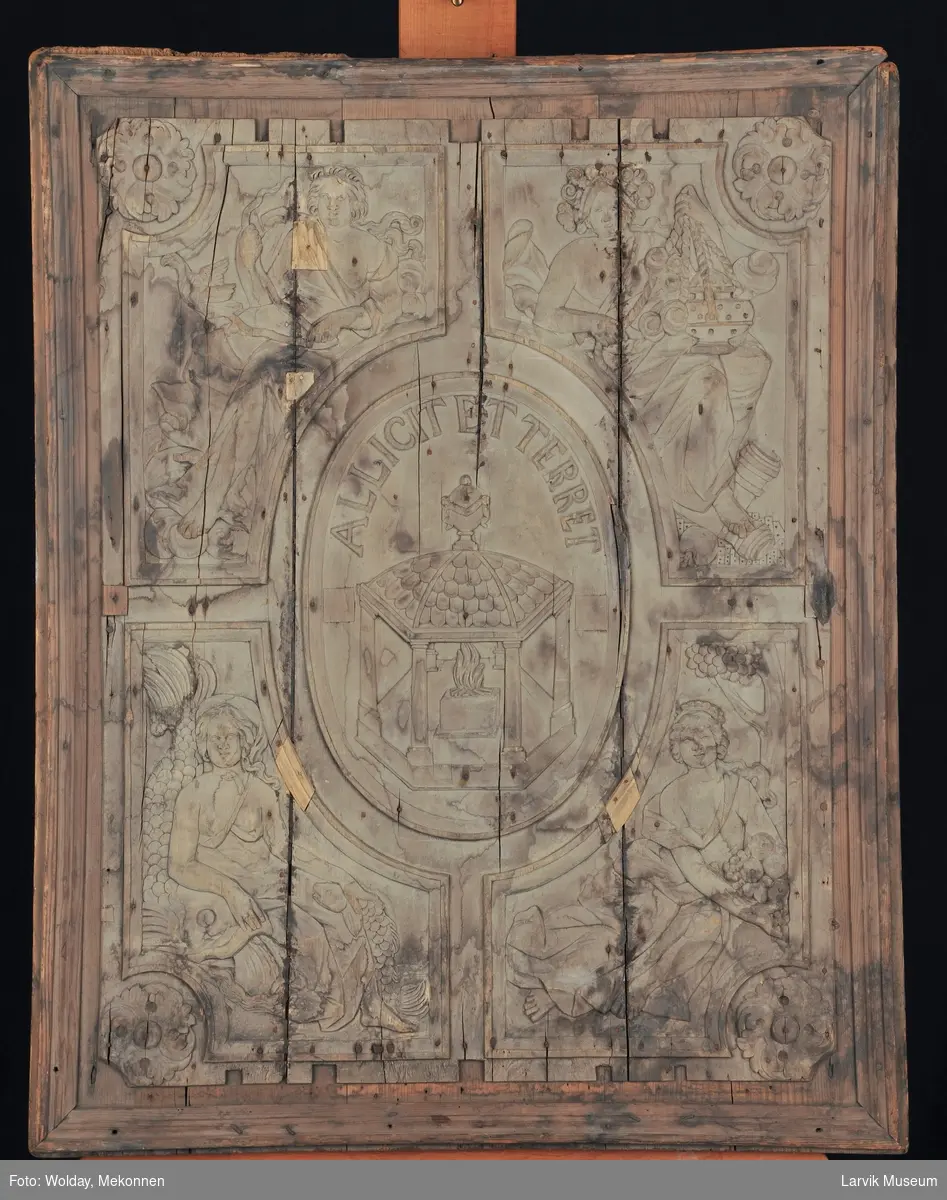 De fire kvinnefigurer skal forestille "De fire elementer", nemlig luft, ild, vann og jord.
I midtfeltet; et tempel med brennende alter. "Allicet et terret" betyr "Den lokker og skremmer"