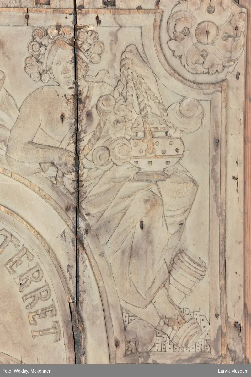 De fire kvinnefigurer skal forestille "De fire elementer", nemlig luft, ild, vann og jord.
I midtfeltet; et tempel med brennende alter. "Allicet et terret" betyr "Den lokker og skremmer"